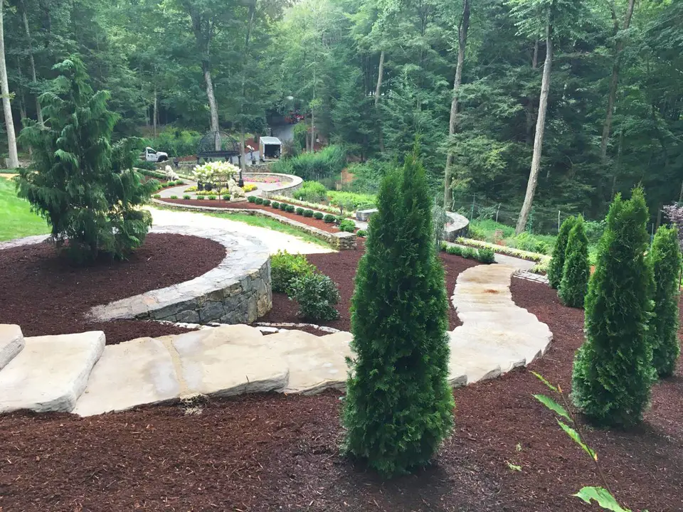 Stone path and garden beds with evergreen plantings